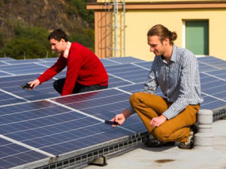 Aleš Doucek (vpravo) a Lukáš Polák u instalovaných fotovoltaických panelů na střeše v Řeži.